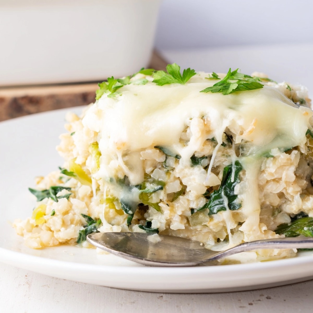 Warm, savory Alfredo Cauliflower Rice Casserole ready to serve, garnished with świeże parsley.