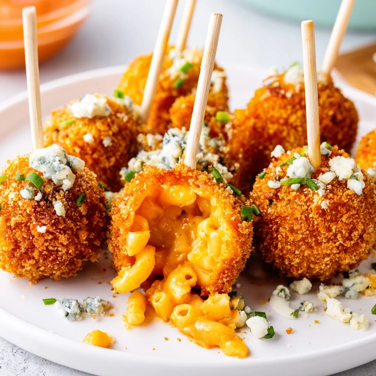 Golden-browned Spicy Buffalo Pumpkin Mac Pops stacked on a platter, ideal for game day.