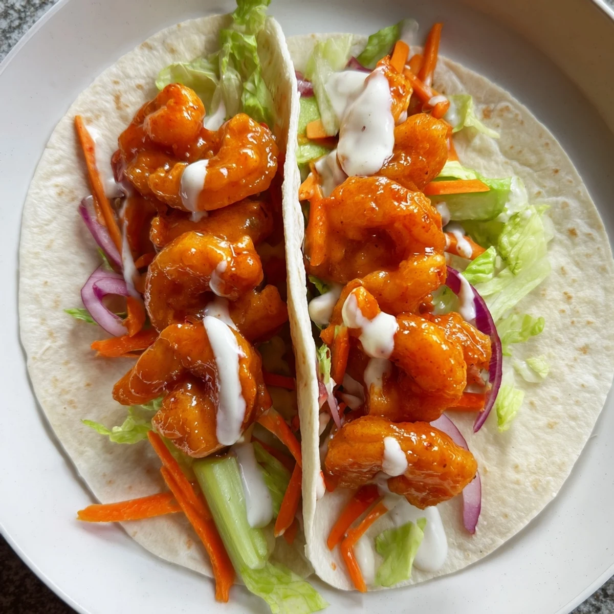 Tempting Buffalo Shrimp Wraps with vibrant veggies and creamy ranch dressing, ready to eat.