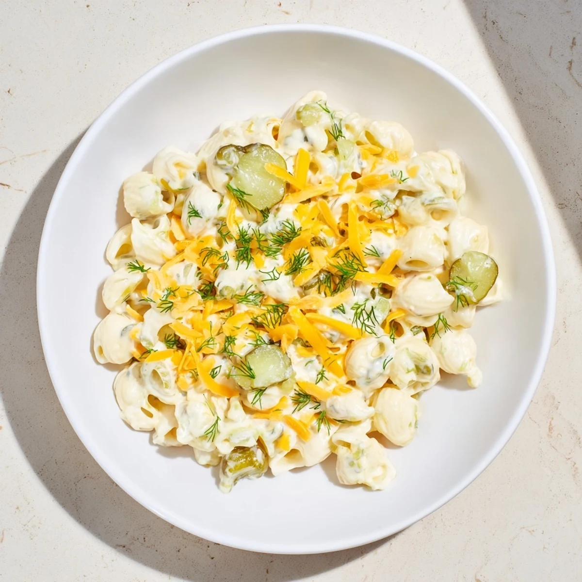 Creamy Pickle Mac and Cheese, with bubbly cheese and vibrant green dill pickle pieces throughout.