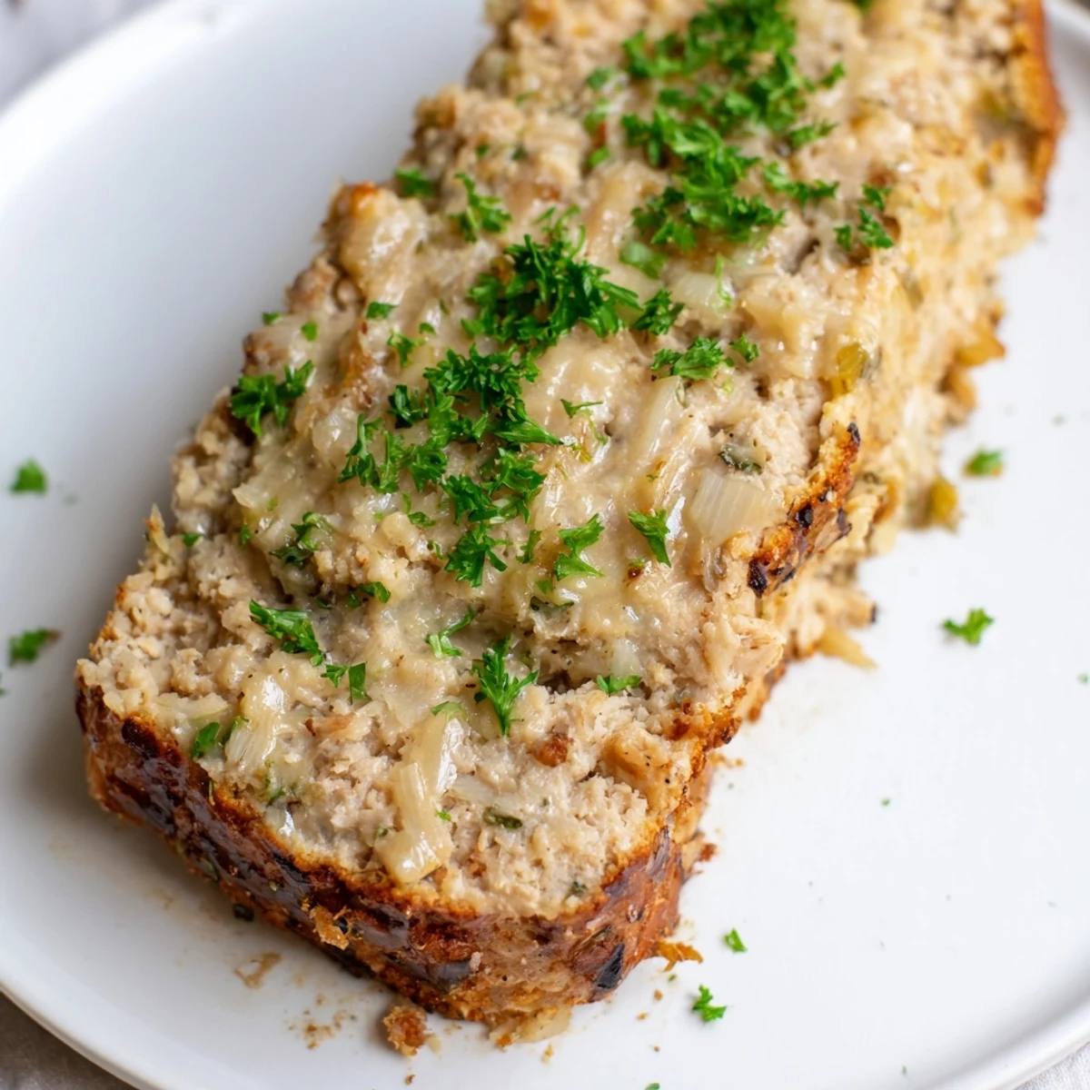 A savory, steaming slice of Juicy Garlic Parmesan Chicken Meatloaf, perfect for a hearty meal.