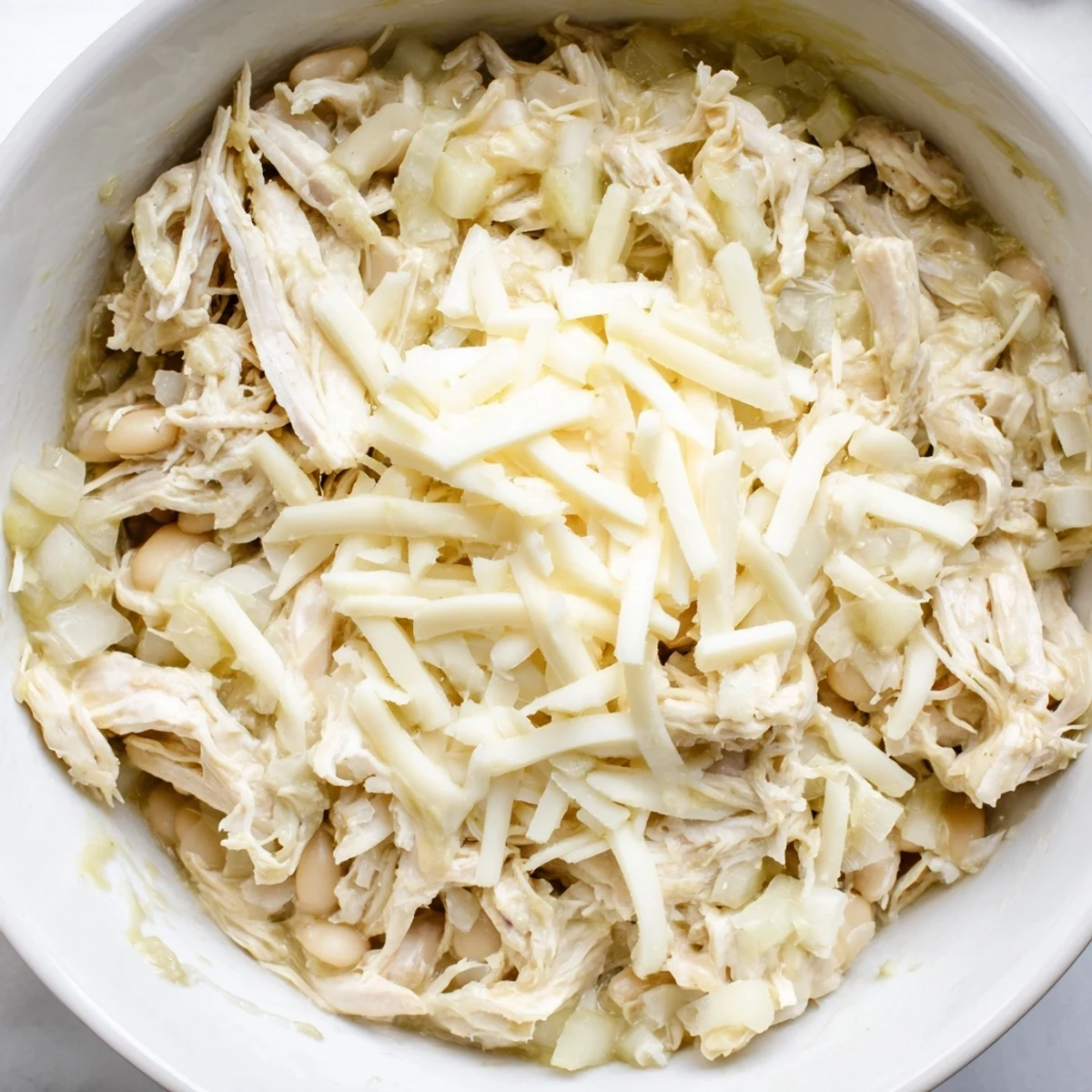 A comforting close-up of hearty 35-Minute White Cheddar Apple Chicken Chili with visible white beans and spices.