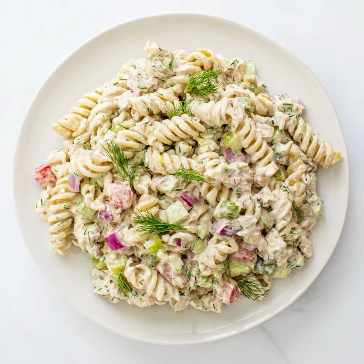 Close-up of a delightful Dill Pickle Chopped Pasta Salad, showing fresh dill and diced cheddar cheese.