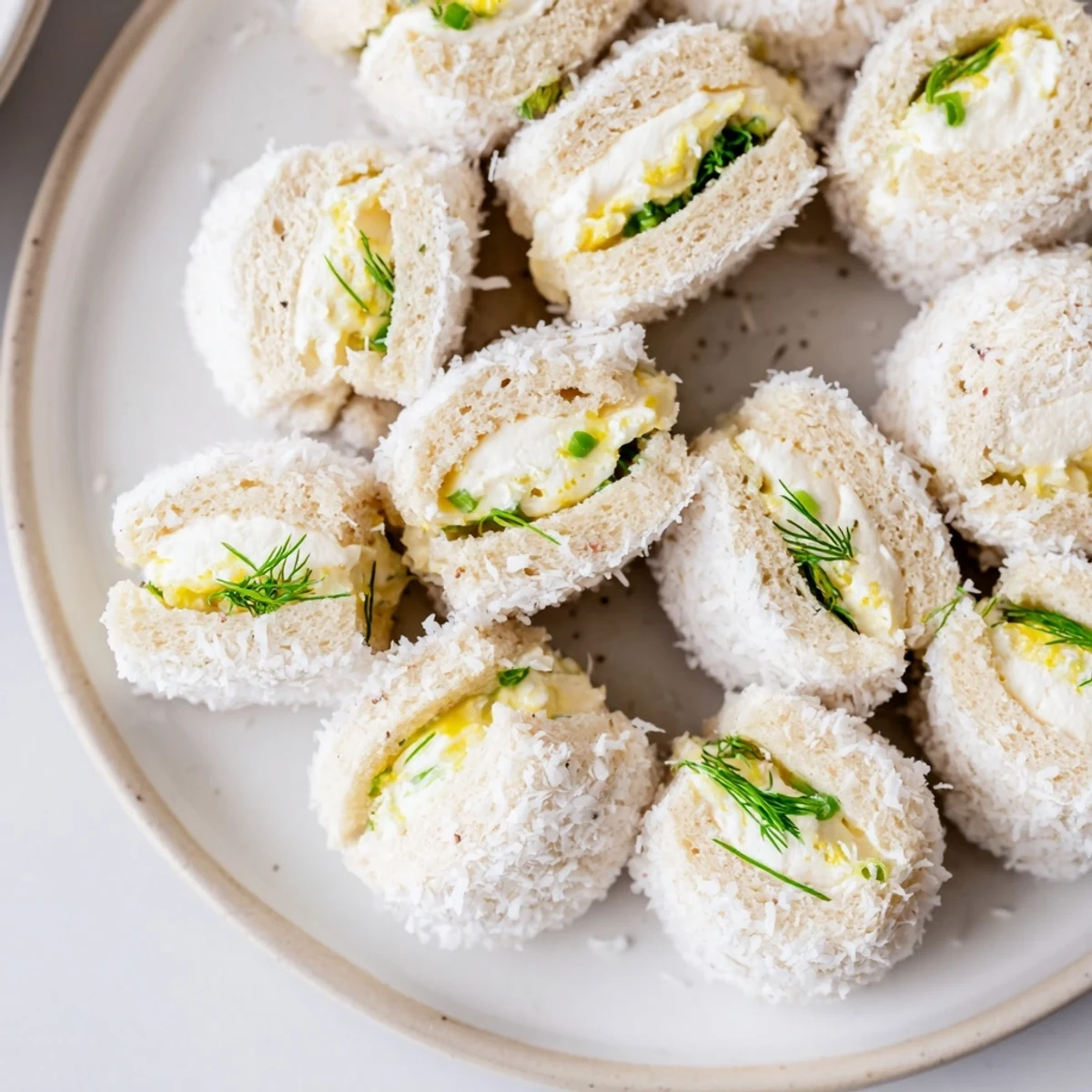 Miniature Snowball Tea Sandwich Bites with visible chives offer a delightful bite of flavor and texture.