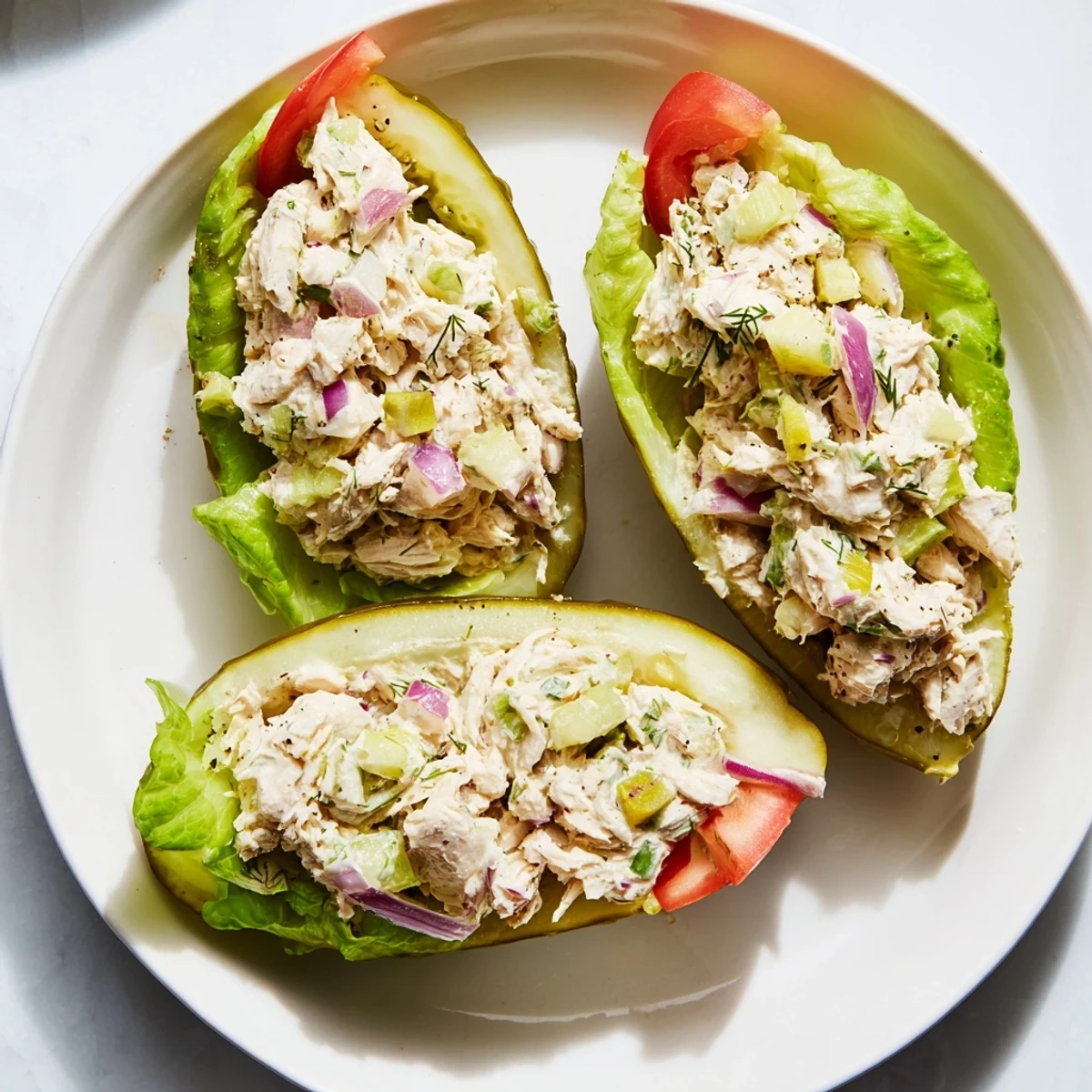 Close-up of a loaded pickle sandwich with chicken salad, perfect for a picnic spread.