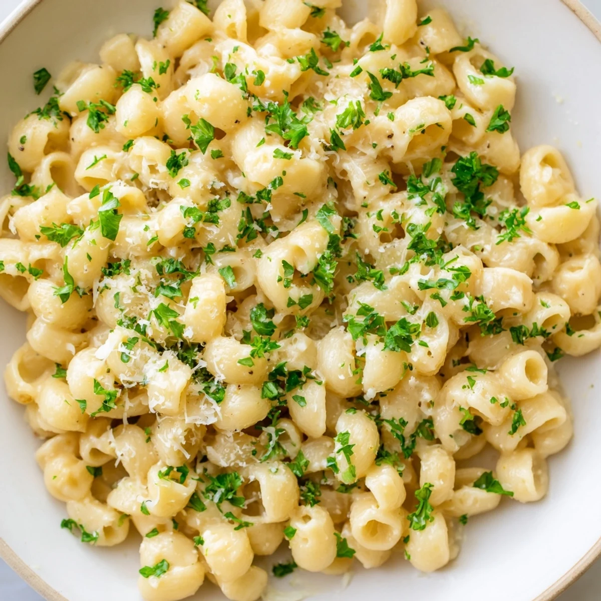 Creamy ditalini pasta glistening, coated in a luscious garlic-infused sauce, ready to serve and enjoy.