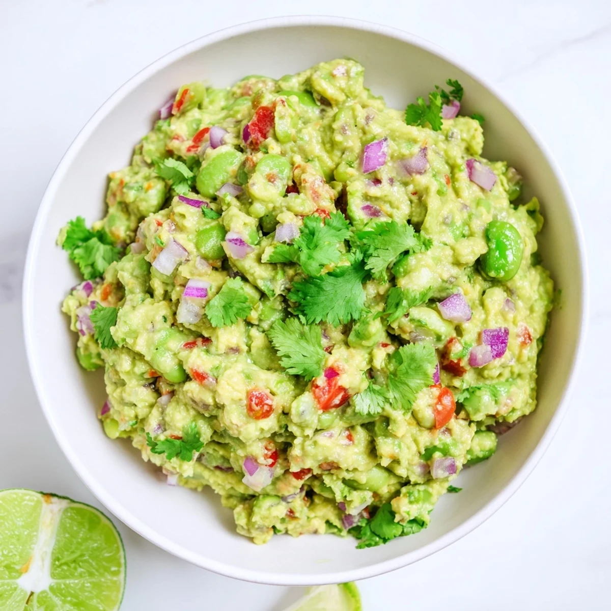 Bright and creamy edamame guacamole served with crisp tortilla chips, ready for dipping and enjoying.