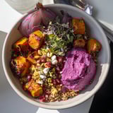 Colorful roasted winter vegetables in a cozy Spiced Winter Bowl with ube-coconut purée.  