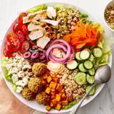 Guests enjoy creating personalized meals with grilled chicken, tofu, and vibrant toppings.  