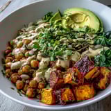 A wholesome vegetarian bowl piled high with garlicky spinach and topped with fresh avocado slices.