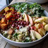 Bright pomegranate seeds and crunchy pepitas top a hearty Kale Harvest Grain Bowl, drizzled with tangy maple Dijon dressing.