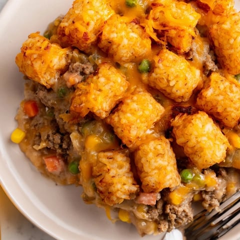 Crispy Sweet Potato Tater Tot Casserole topped with melted cheddar cheese and ground turkey.