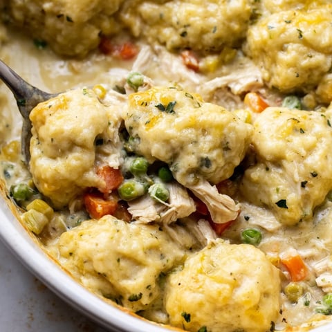 Hearty chicken and dumplings casserole topped with golden, fluffy dumplings ready to serve.  