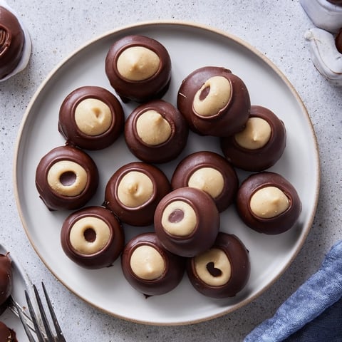 Creamy peanut butter buckeyes, partially dipped in dark chocolate, are perfect American holiday treats.