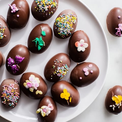 Vibrantly decorated Easter egg candies displayed on a decorative platter for a festive treat.