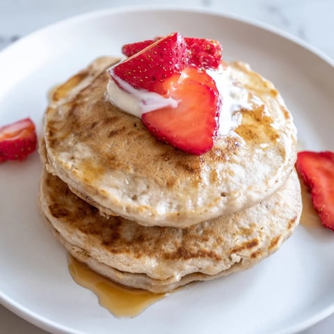 Fluffy Protein Banana Pancakes, golden brown and ready to be topped with fresh berries.