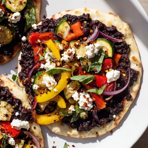Naan Bread Pizza piled high with roasted vegetables, creamy feta, and savory olive tapenade.