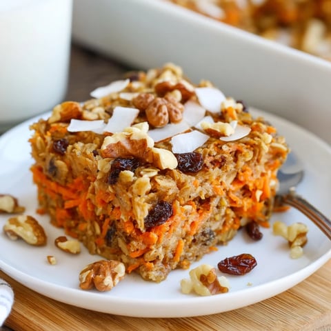 Golden-brown Carrot Cake Baked Oatmeal fresh from the oven, topped with a swirl of maple syrup and creamy Greek yogurt.  