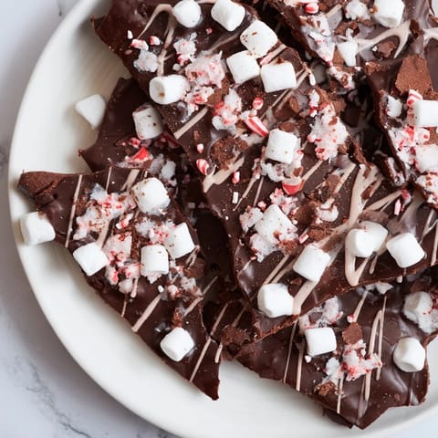Homemade Hot Chocolate Bomb Bark, featuring melted chocolate, marshmallows, and festive, peppermint-infused toppings.
