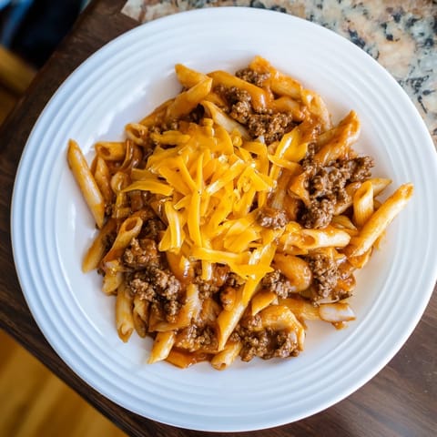 Easy Beef Enchilada Pasta, a one-pot meal, features tender pasta, ground beef, and melted cheese.