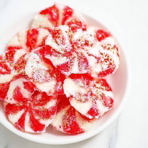 See the shiny, vibrant red Express Peppermint Candy Bows, sprinkled with edible glitter, ready for your party.