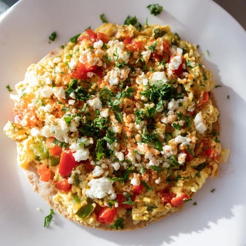 Golden-brown Turkish Menemen Eggs Pizza topped with creamy feta, perfect for a hearty brunch.