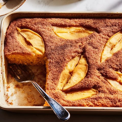Golden Baked Apple Cake with cinnamon-spiced apple slices, fresh from the oven and served warm for a cozy breakfast.