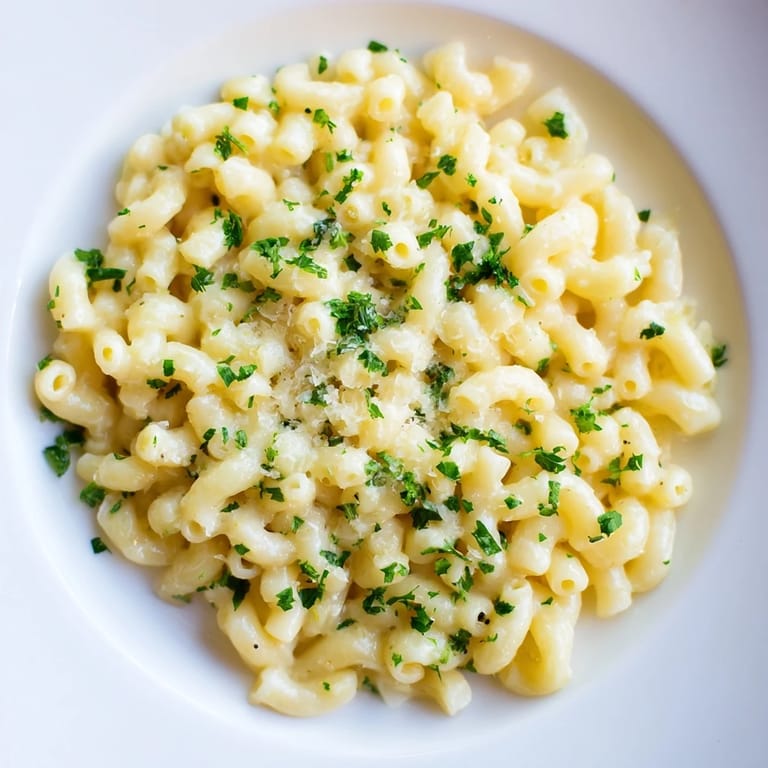 Golden, perfectly cooked ditalini pasta swathed in creamy garlic sauce, ideal for a satisfying vegetarian dinner.