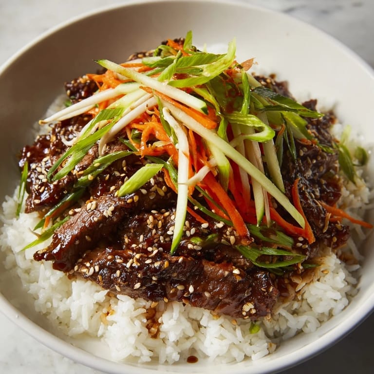 A steaming Bulgogi Beef Bowl, showcasing flavorful marinated beef atop fluffy rice, garnished with sesame seeds.