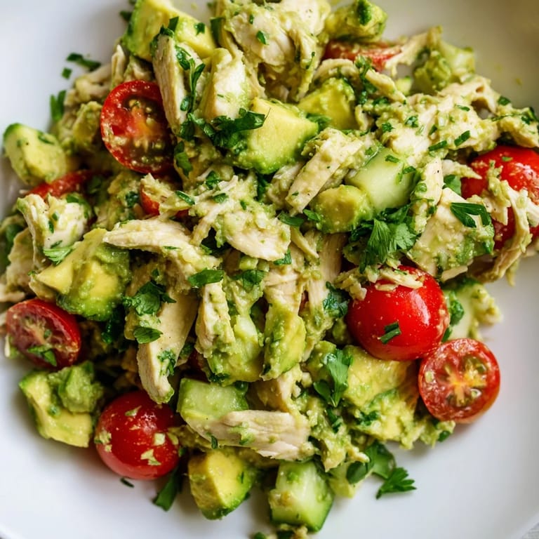 Serving suggestion for Avocado Chicken Salad in lettuce cups, garnished with lime wedges and fresh cilantro, perfect for a healthy lunch.