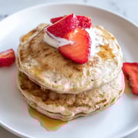Fluffy Protein Banana Pancakes, golden brown and ready to be topped with fresh berries.